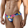 Vibrant geometric-patterned MetroMaleWear Picasso bikini 5103-M87 men’s swim trunks in blue pink yellow and white with black logo tag