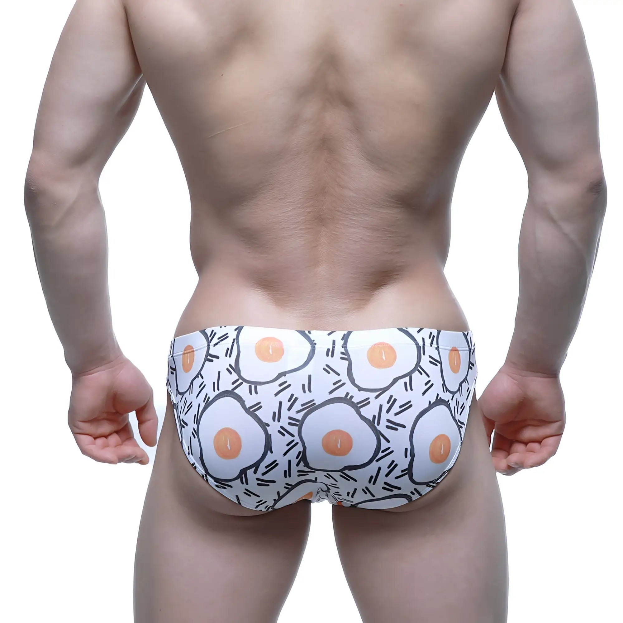 White swim trunks by MetroMaleWear featuring a playful fried egg pattern with orange yolks and black outlines