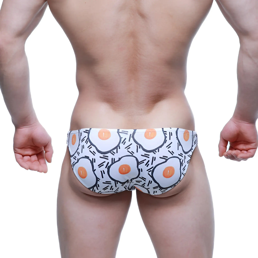 White swim trunks metro malewear sunny side lowrise bikini with cartoon fried egg pattern and black line accents