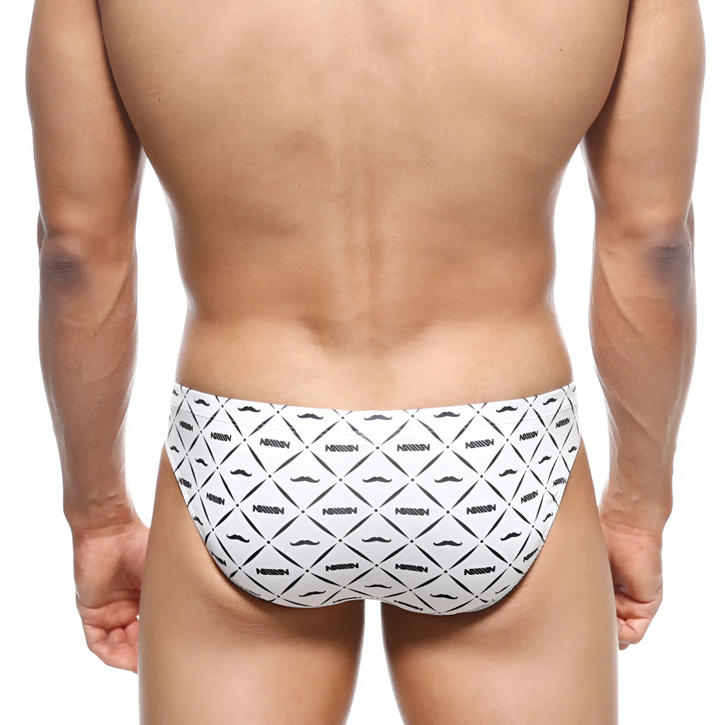 White swim trunks with black geometric mustache pattern and nassim text from metromalewear vasco hip brief caballero 5103-03