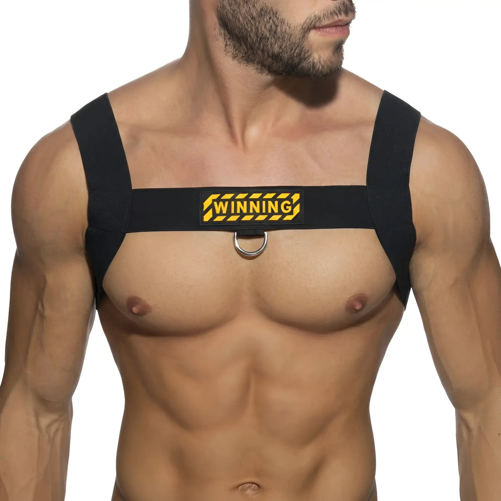Black fabric shoulder harness with yellow and black winning logo patch and central silver metal ring by metromalewear