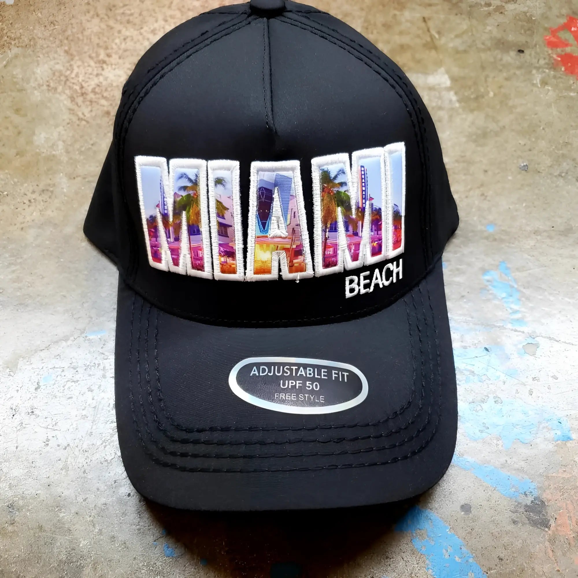 Black trucker hat with colorful embroidered miami design featuring palm trees and cityscape in vibrant hues