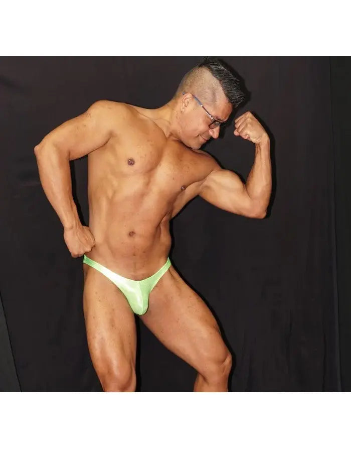 Fluor green micro bikini underwear by Arroyman featuring a minimal design worn by a model showcasing a muscular physique.