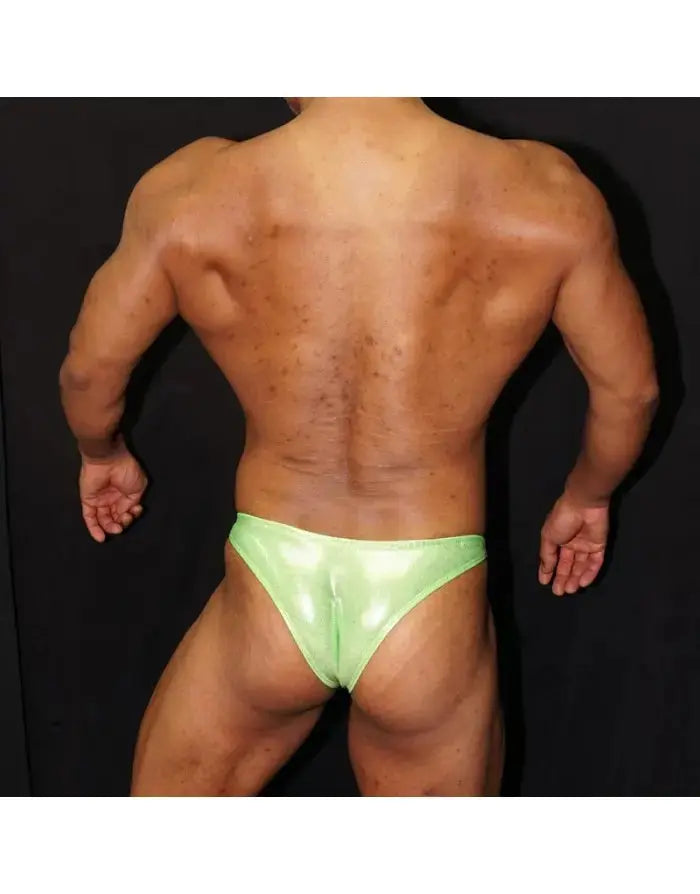 Fluor green micro bikini posing suit by Arroyman featuring a shiny finish and minimal coverage shown on a model from the back.