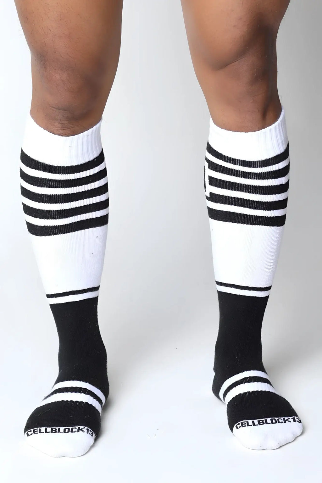 Midfield knee high socks in black and white with ribbed texture and bold horizontal stripes on upper leg and toe area
