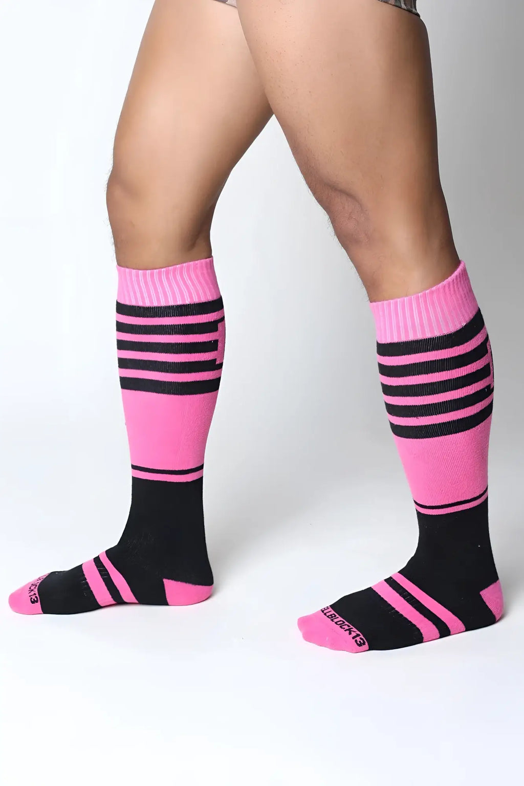 Midfield knee high socks in bright pink and black stripes with ribbed cuff and blueberries logo on the toe