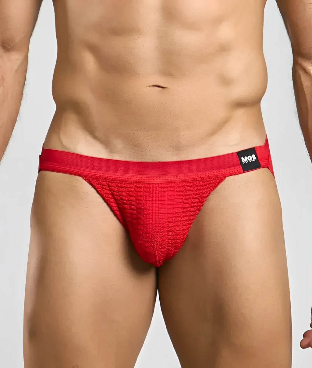 Red textured swim jockstrap briefs with black mob brand tag on waistband designed for swimwear use