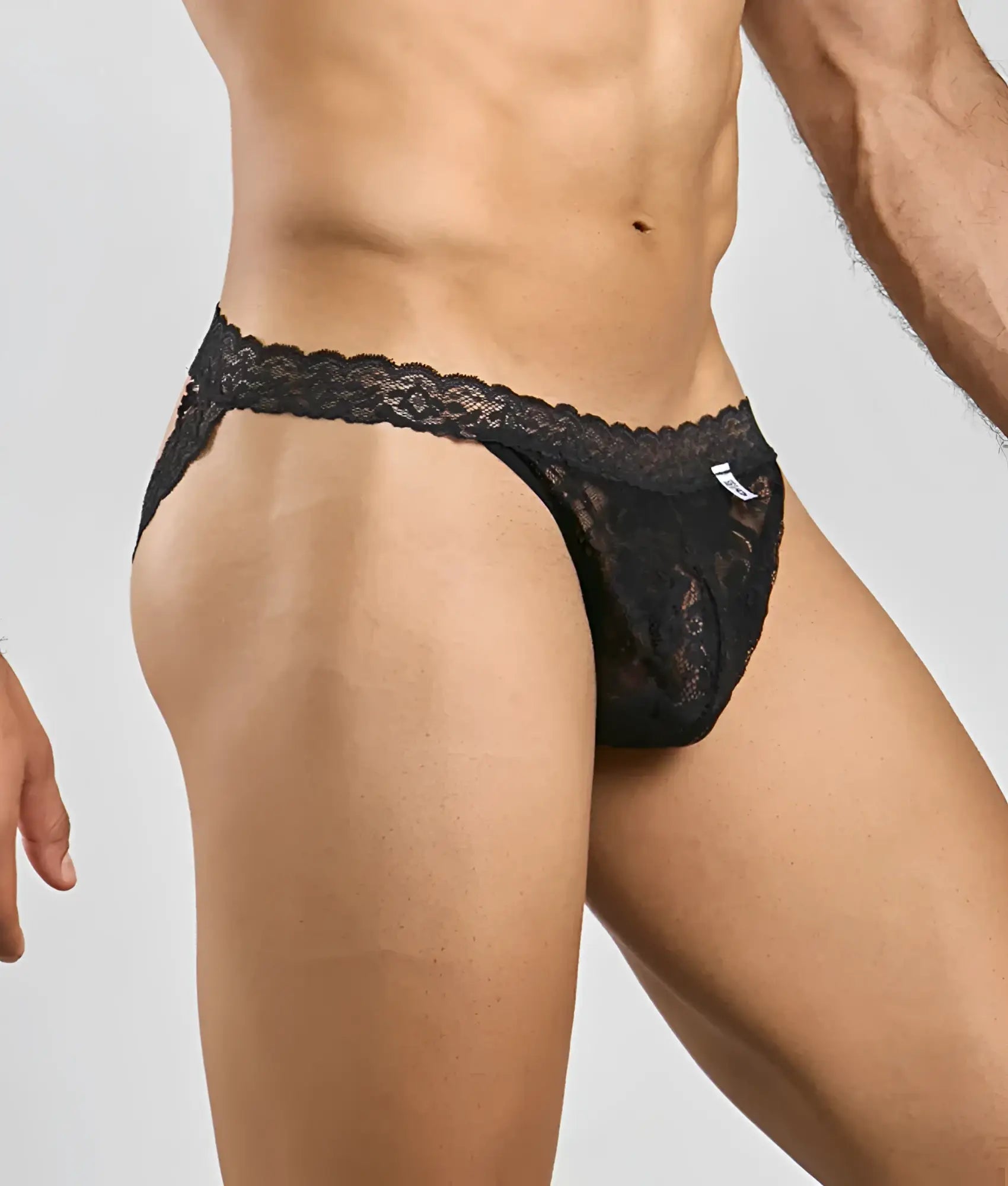 Black lace thong jockstrap with intricate floral patterns and scalloped waistband from mob men’s lace collection