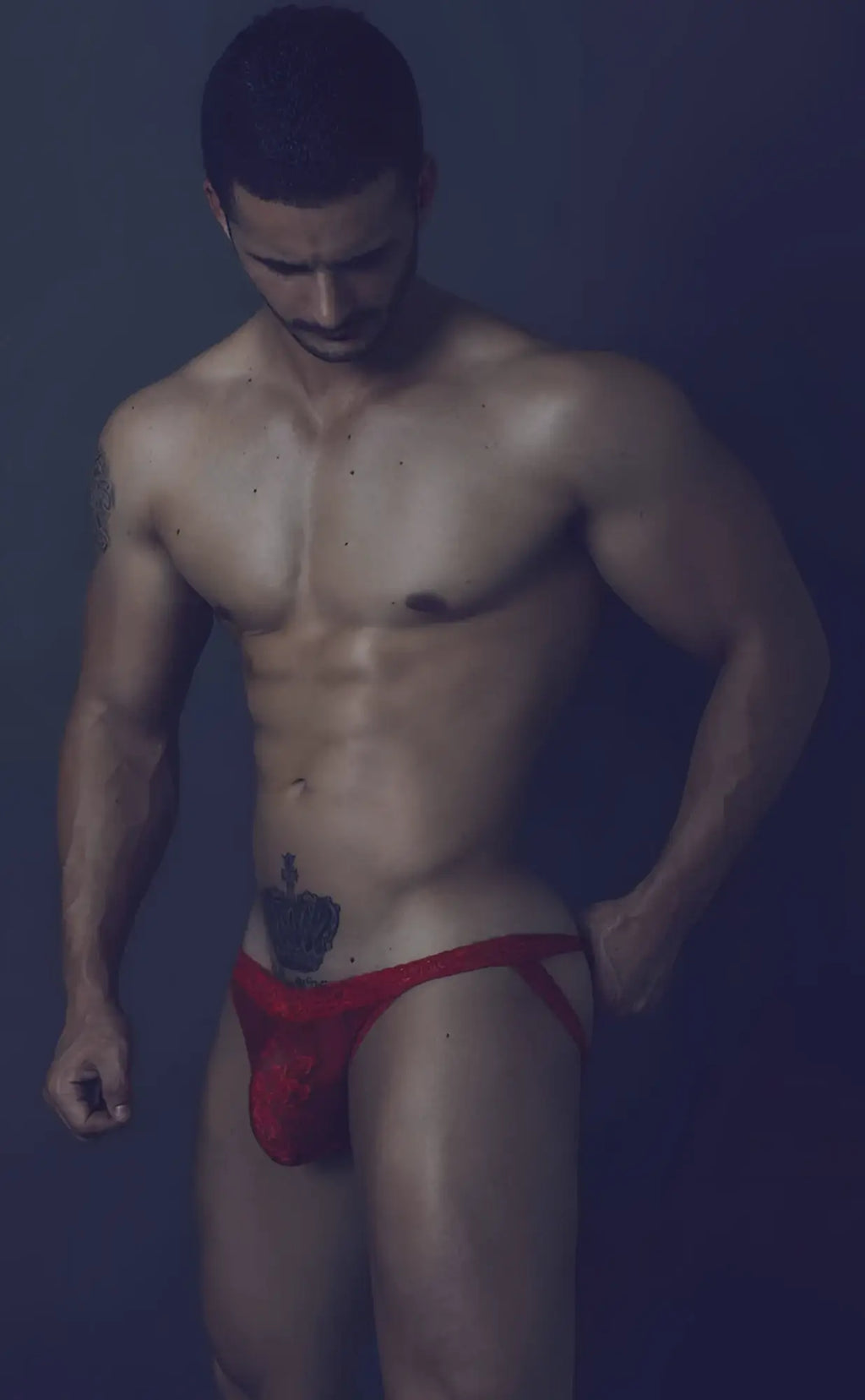 Red athletic lace jockstrap with small embroidered logo on front for men designed for support and comfort