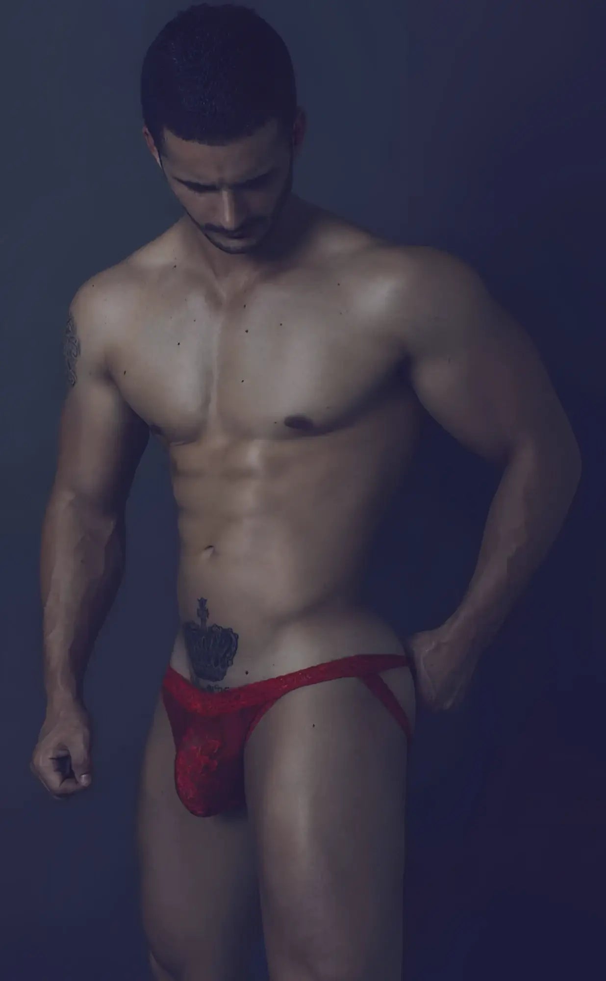 Red athletic lace jockstrap with small embroidered logo on front for men designed for support and comfort