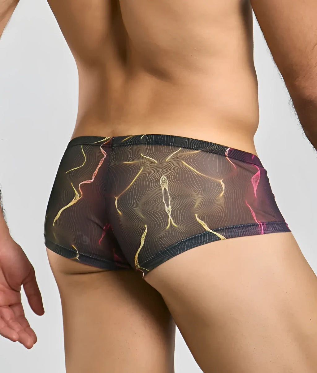 MOB men’s sexy sheer hip briefs in black feature a vibrant abstract pattern of glowing yellow and pink lines