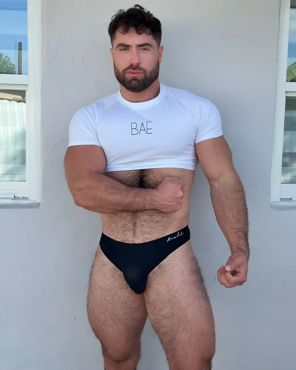 Black briefs with mali embroidered in white script on waistband paired with muscle-fit crop tee daylight bae
