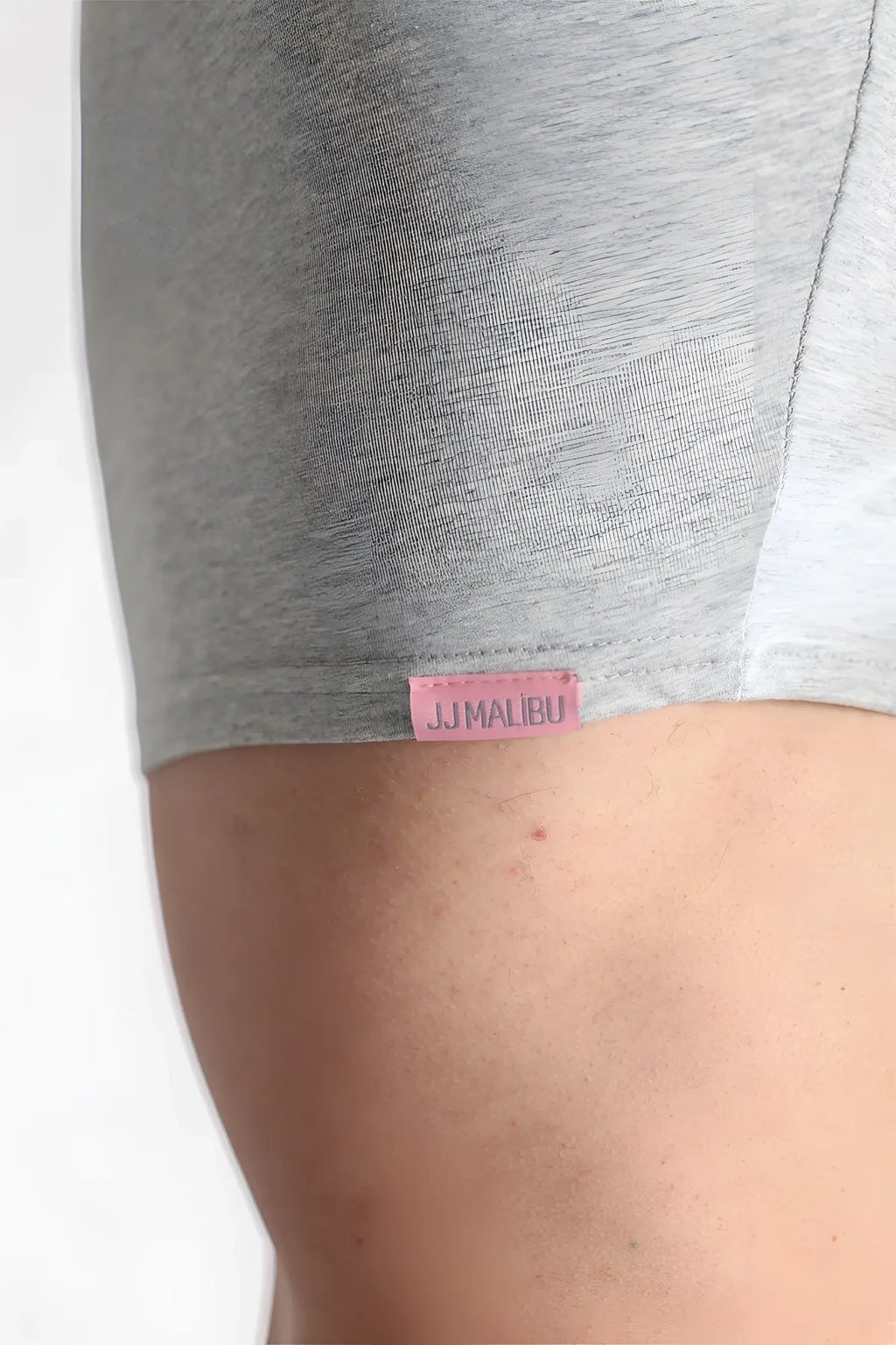 Gray heathered fabric shorts with a pink jjmalbu label at the waistband paired with muscle-fit crop tee free verse