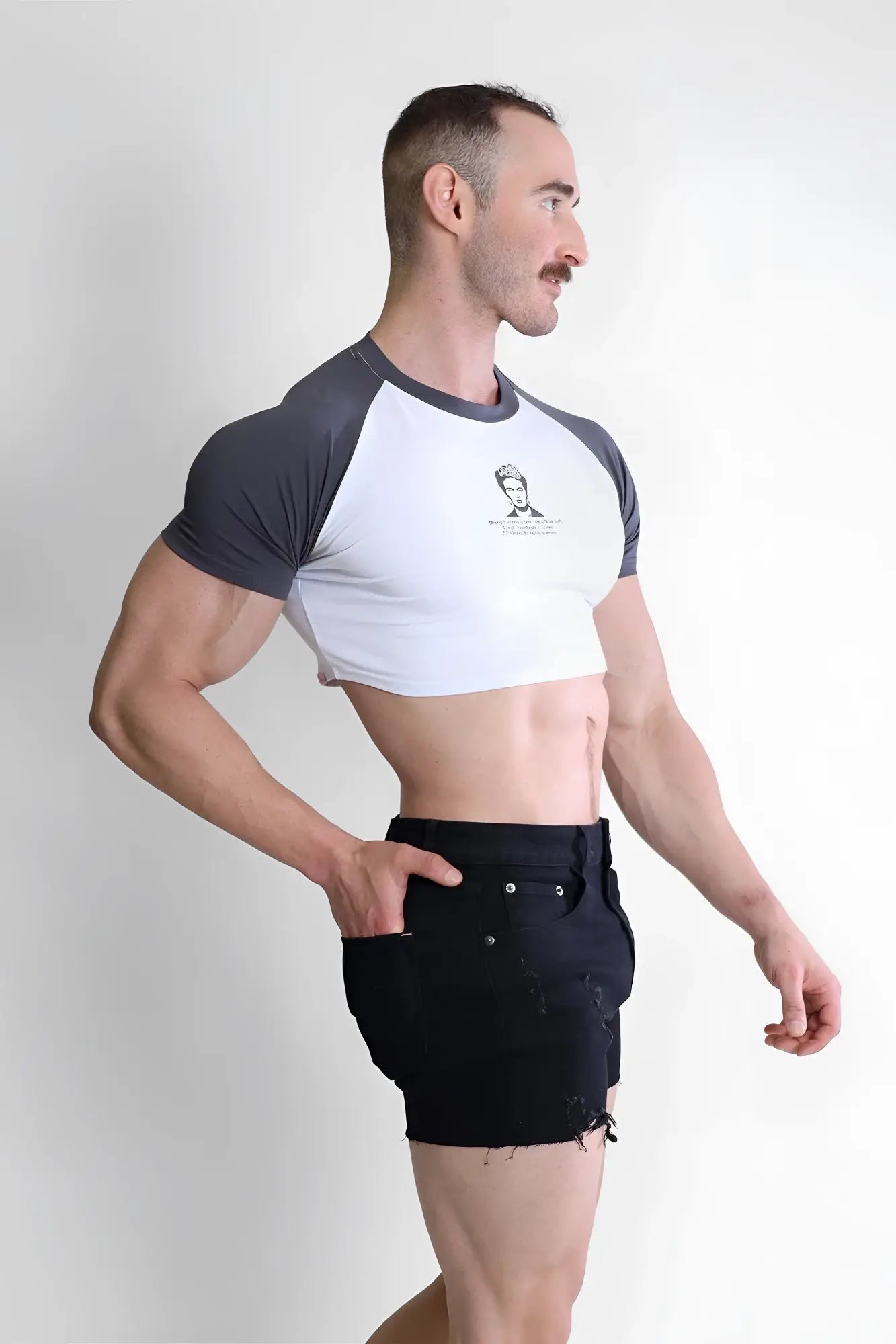 A men’s muscle-fit crop tee with a white body dark gray raglan sleeves and a small chest graphic from Rebel Bloom