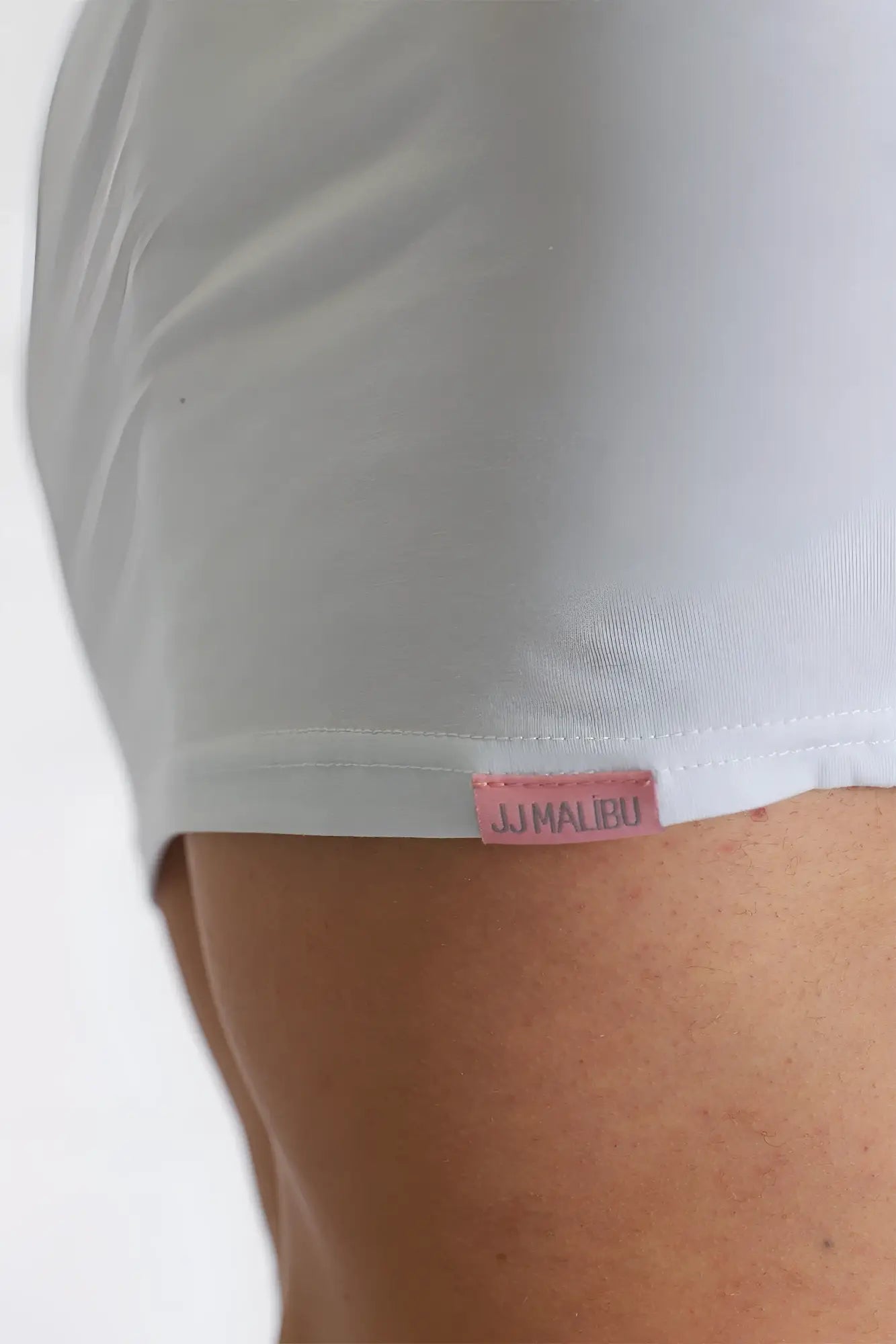 White cotton muscle fit crop tee with pink jumalbu brand tag at hem versatile for casual wear