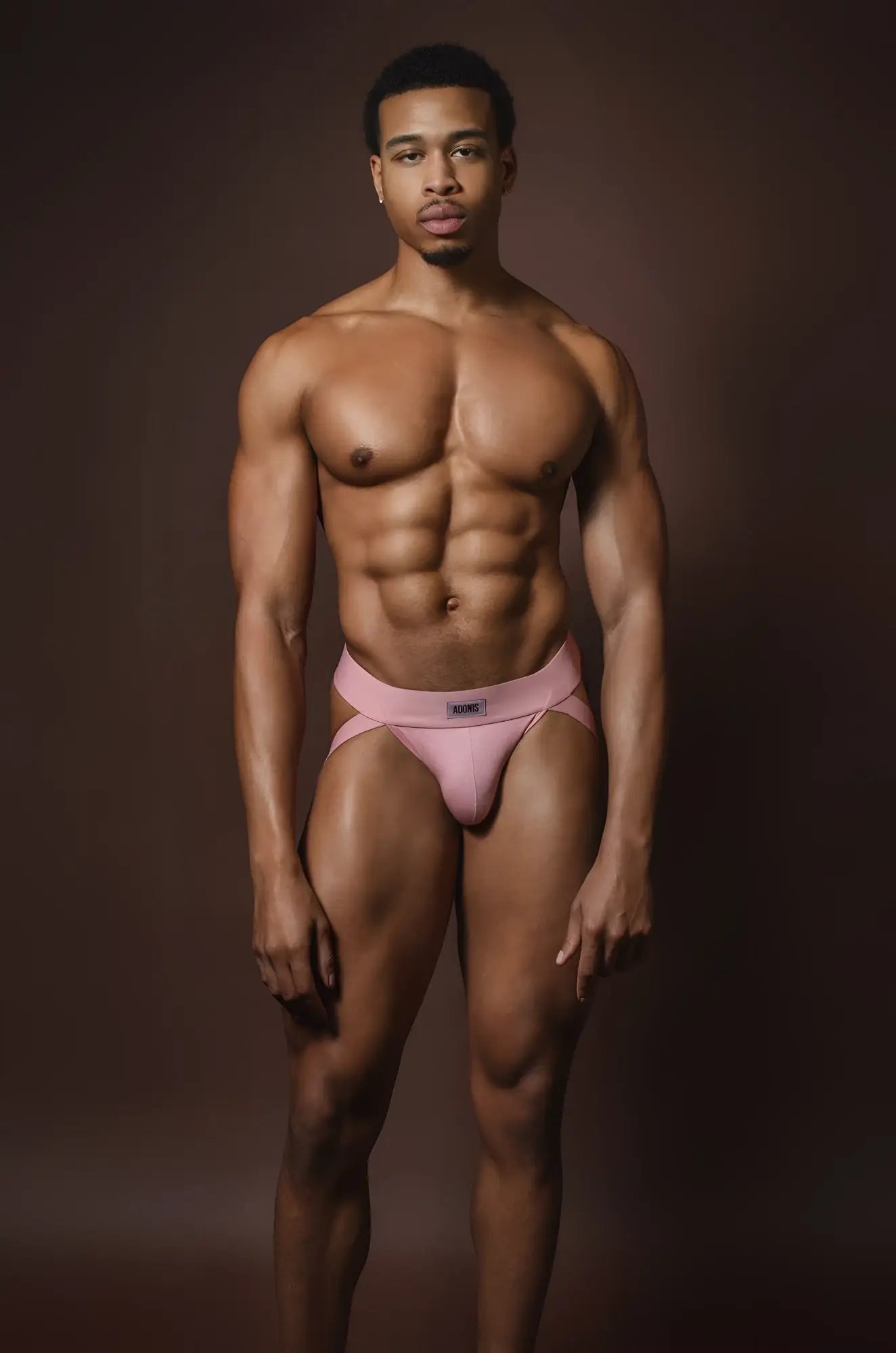 Muted pink jockstrap with a subtle logo on the waistband made from soft athletic fabric shown from the back side