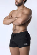 Black muzzle up athletic shorts with drawstring waistband and logo patch on lower left leg for workout use