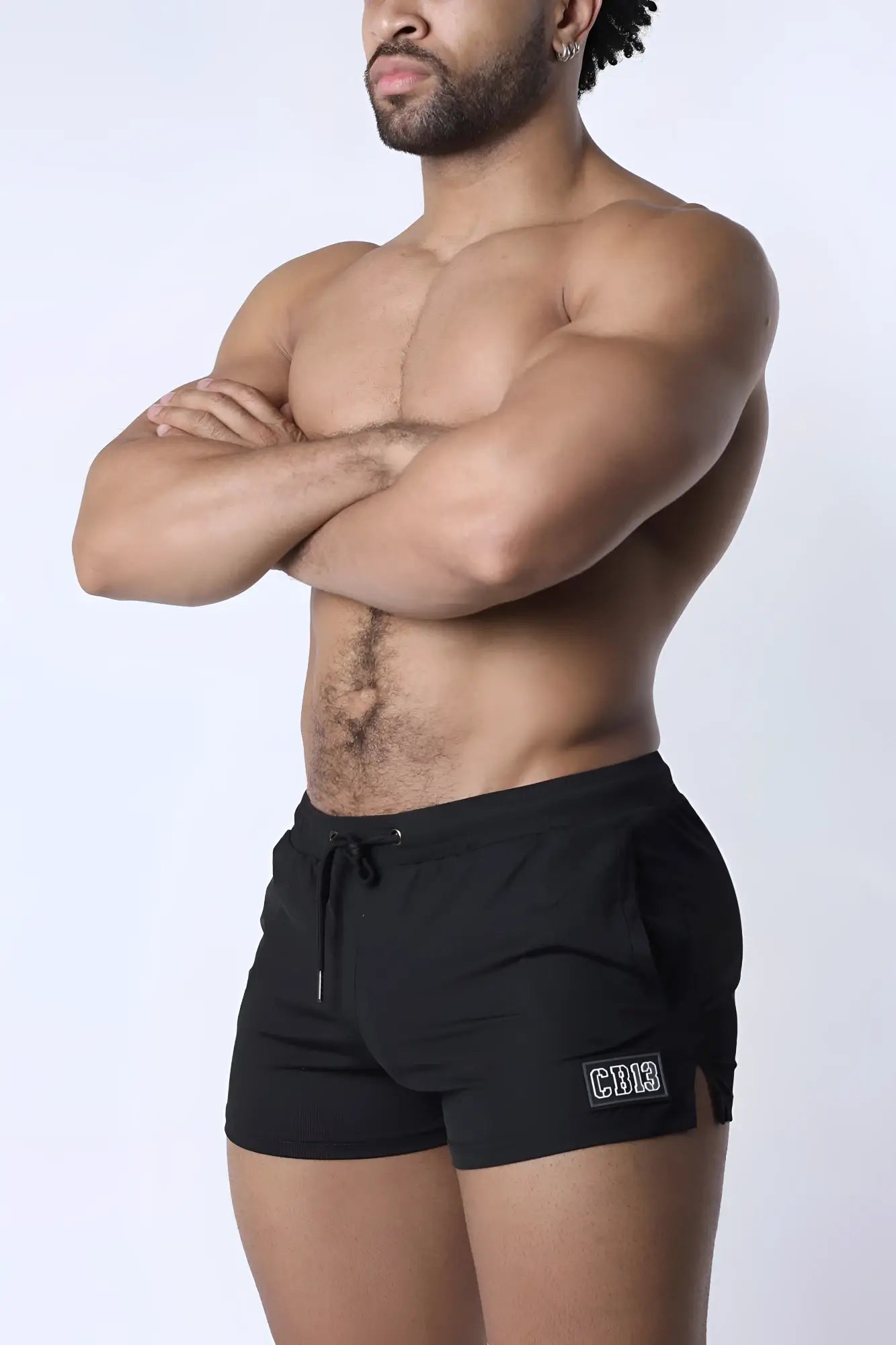 Black muzzle up athletic shorts with drawstring waistband and logo patch on lower left leg for workout use