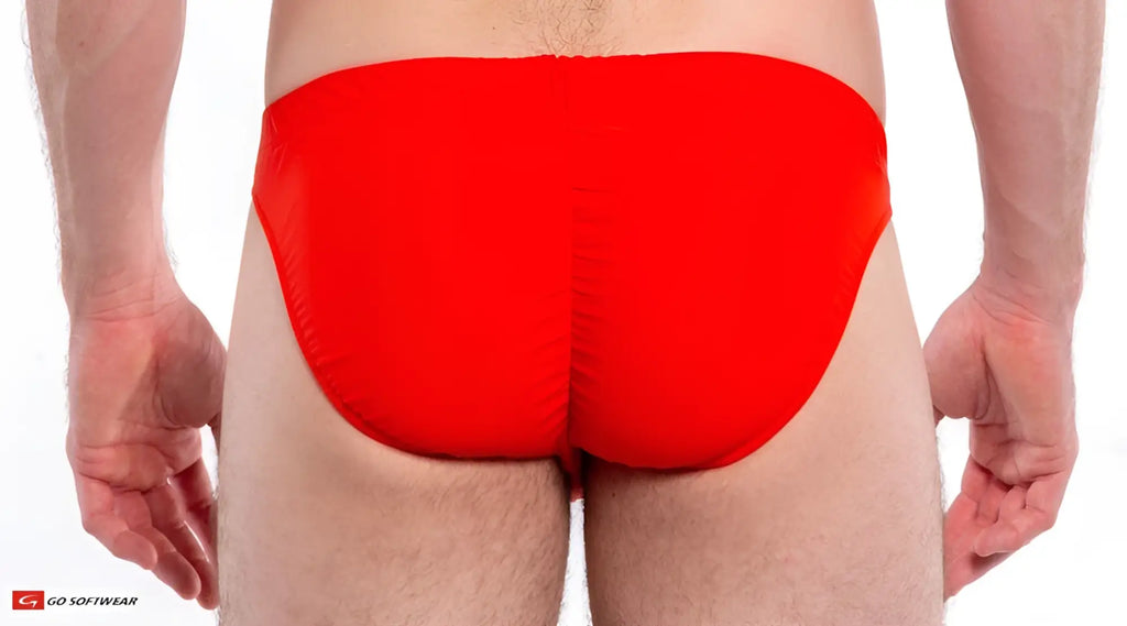 Bright red form-fitting Napoli Buns bikini swim trunks made of smooth stretchy fabric shown from the back side