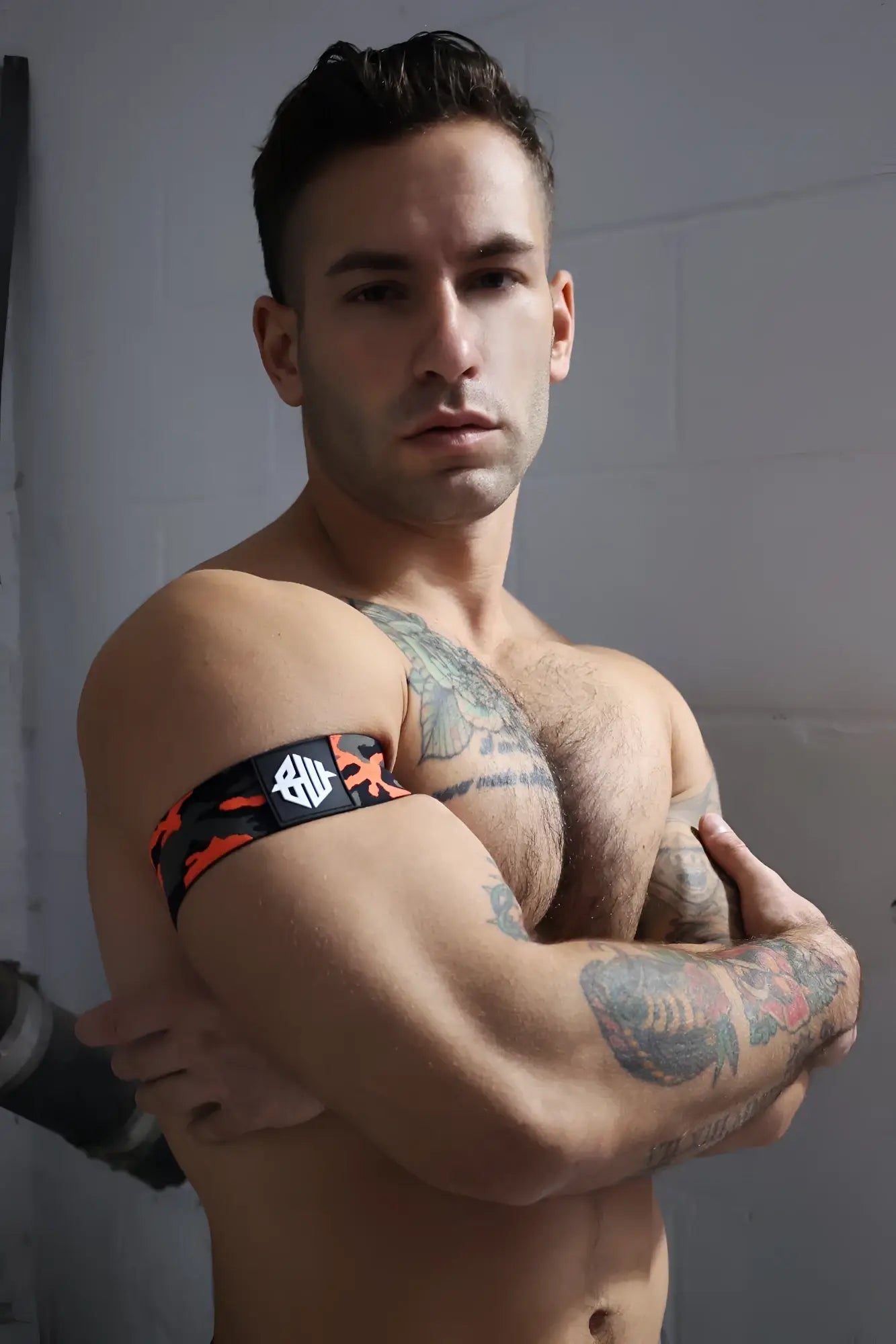 Black and orange neo camo armband with white logo featuring a camouflage pattern for secure fit and style