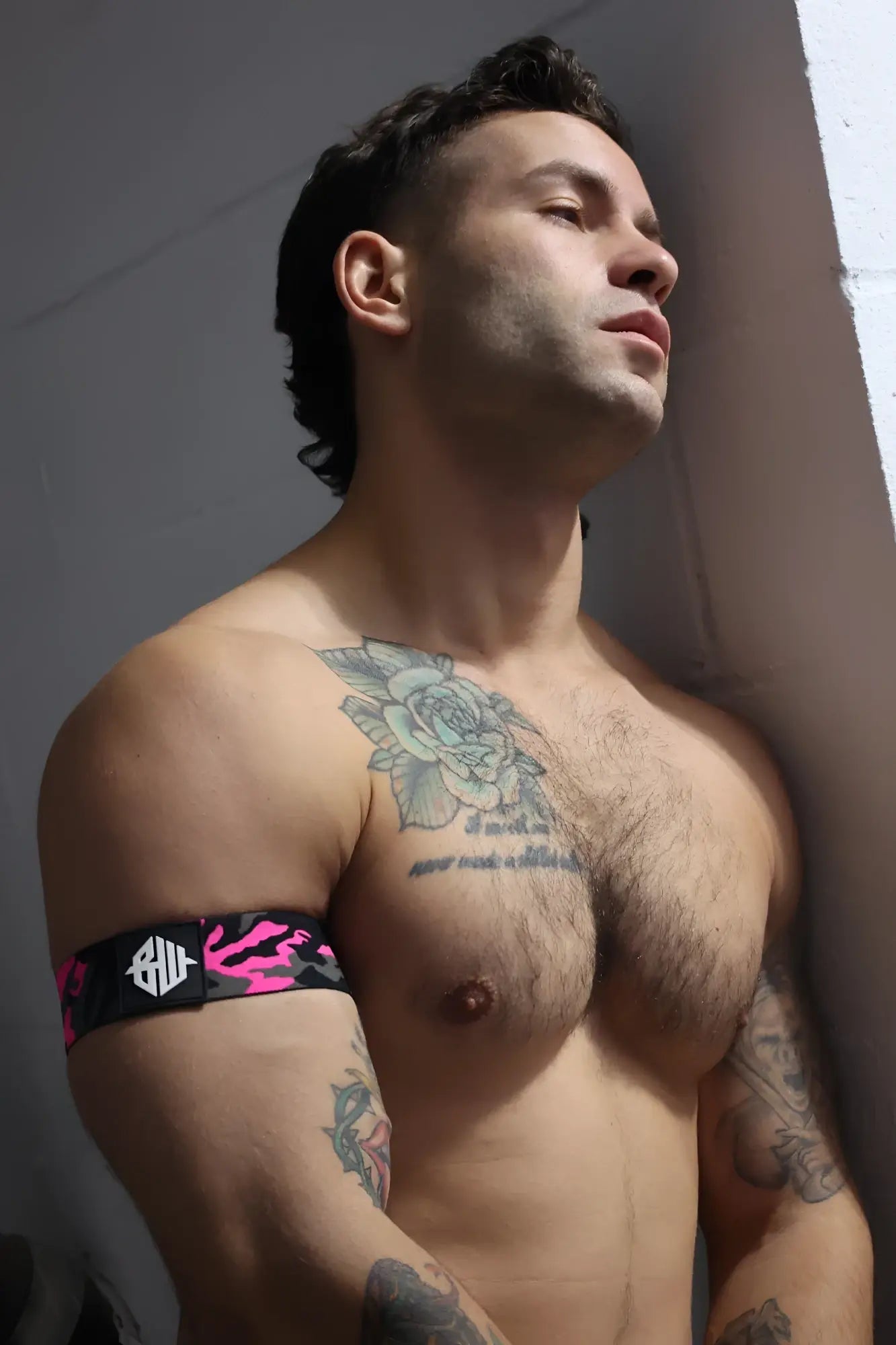 Neo camo armband in black and pink camouflage pattern with white logo designed for comfortable athletic wear