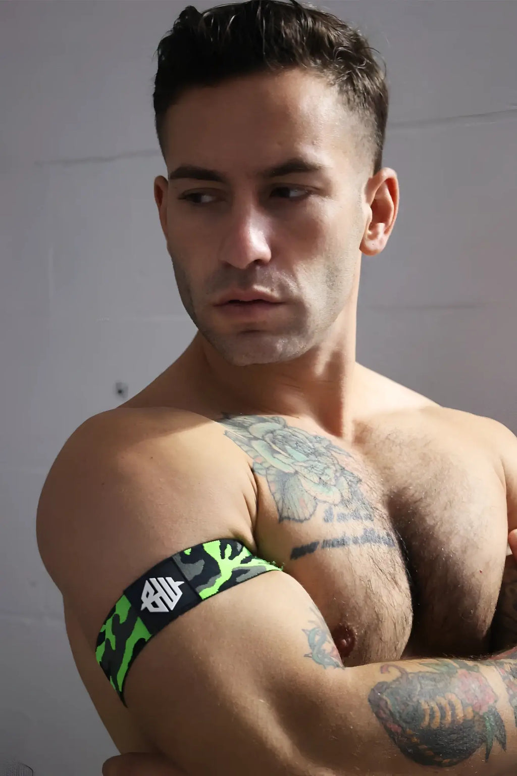 Neo camo armband in neon green and black camouflage pattern with a white logo on a fabric arm band