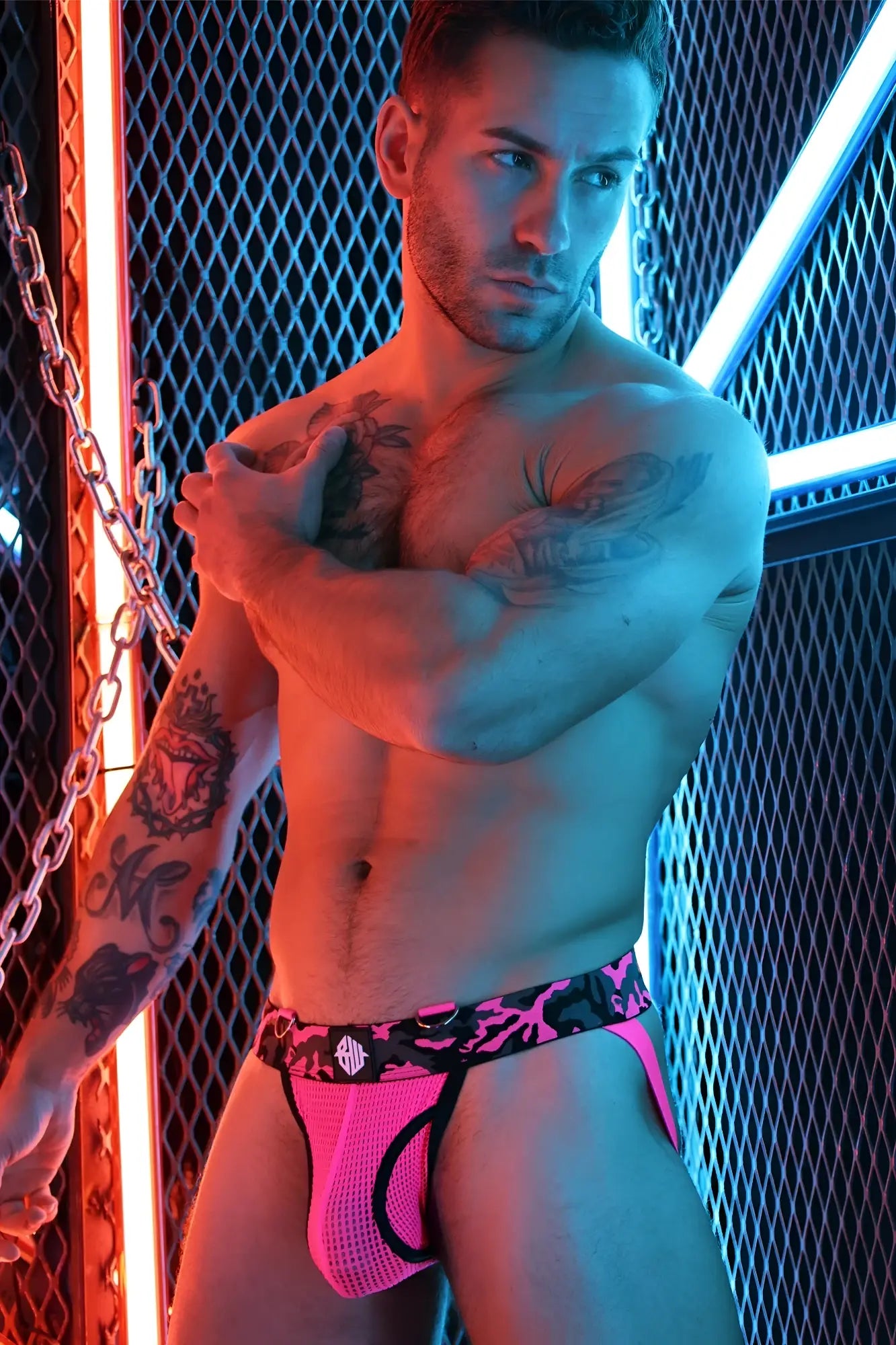 Bright pink mesh briefs with black camouflage waistband and small white logo from neo camo jock collection