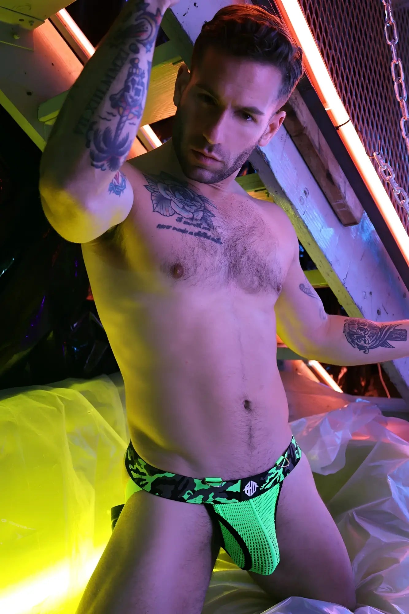 Neon green mesh briefs with black camouflage pattern and white circular logo from neo camo jock collection