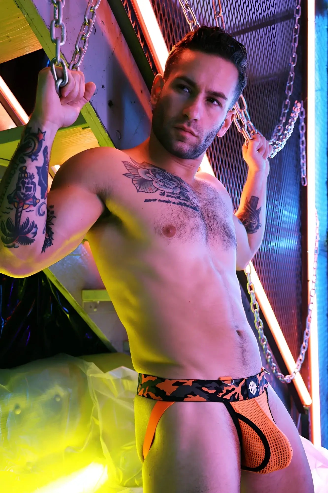 Orange mesh briefs with black camouflage pattern and branded waistband logo from the neo camo jock collection
