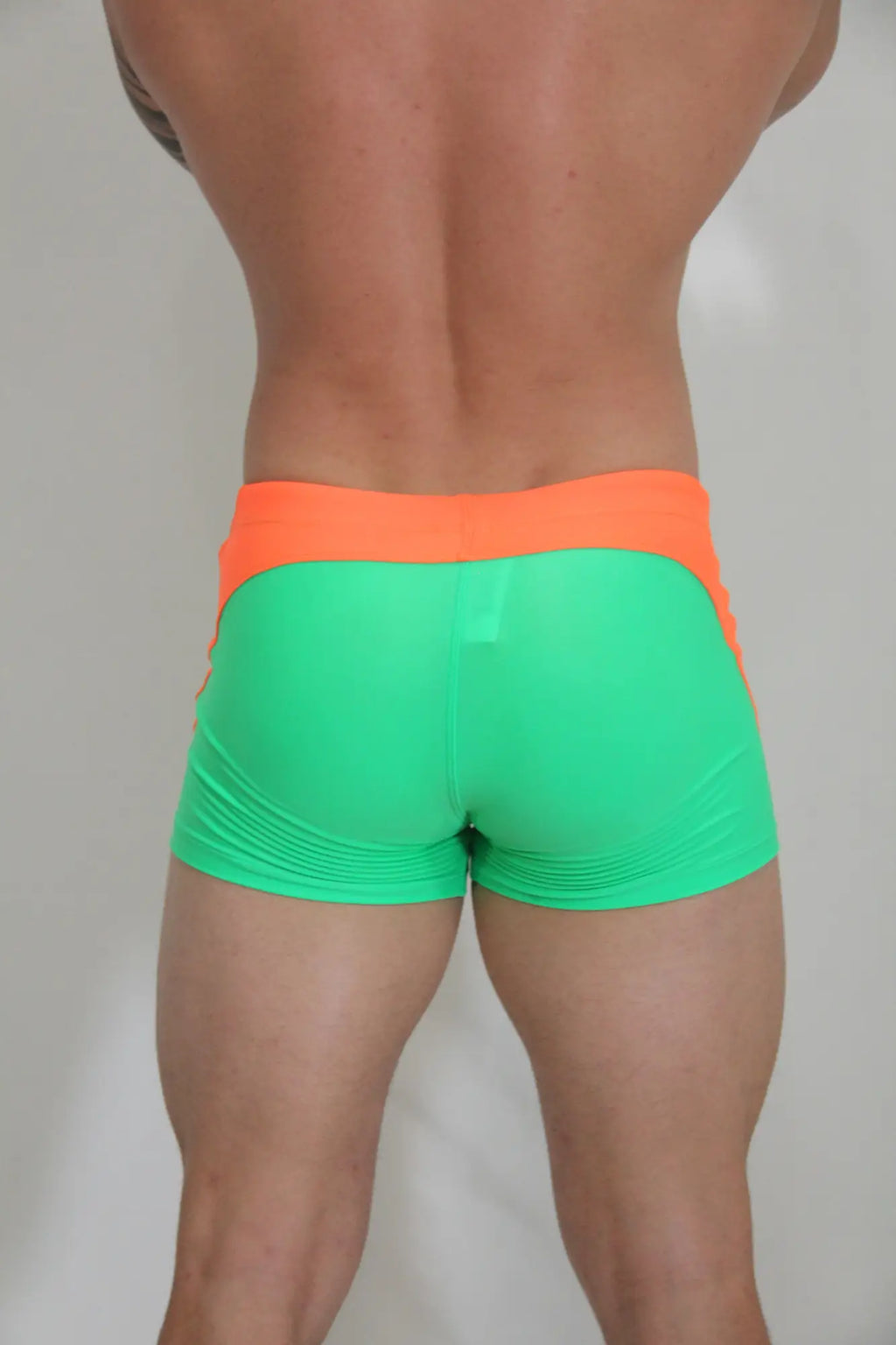 Neon curved sq cut trunk athletic shorts in vibrant neon green and orange with a snug form-fitting design