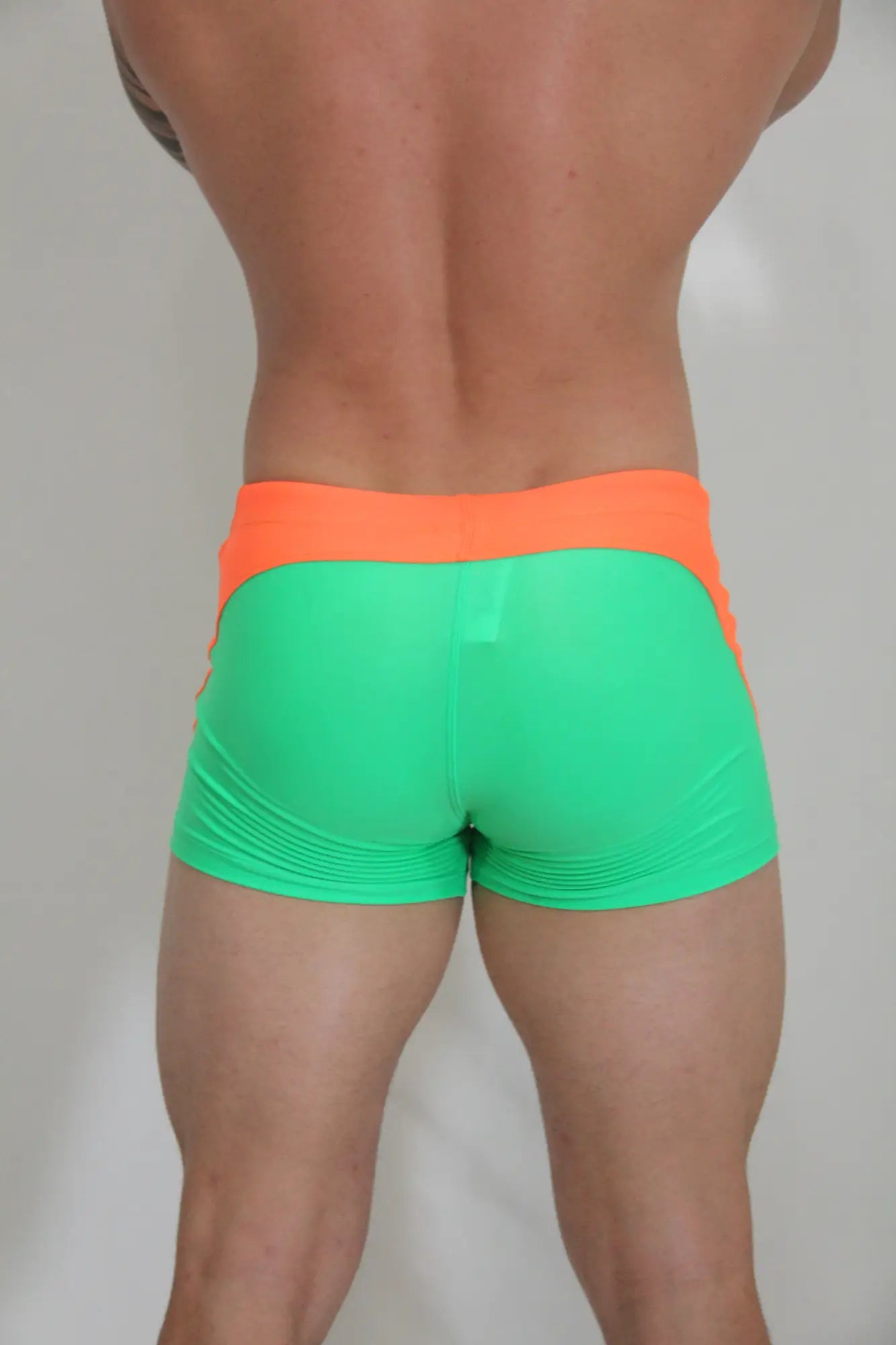 Neon curved sq cut trunk athletic shorts in vibrant neon green and orange with a snug form-fitting design