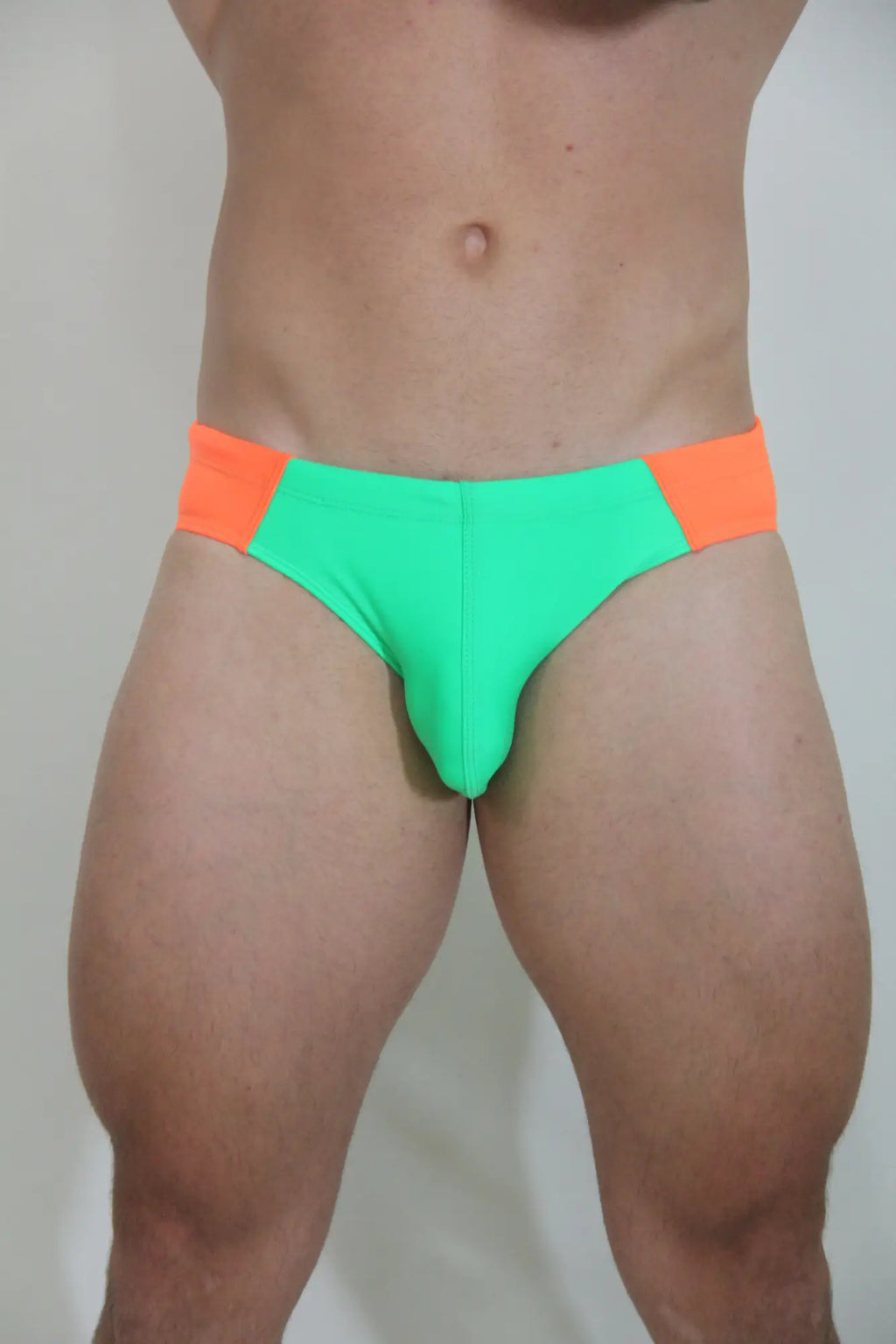 Neon curved swim brief in bright green and orange with a snug form-fitting design for swimming and beachwear