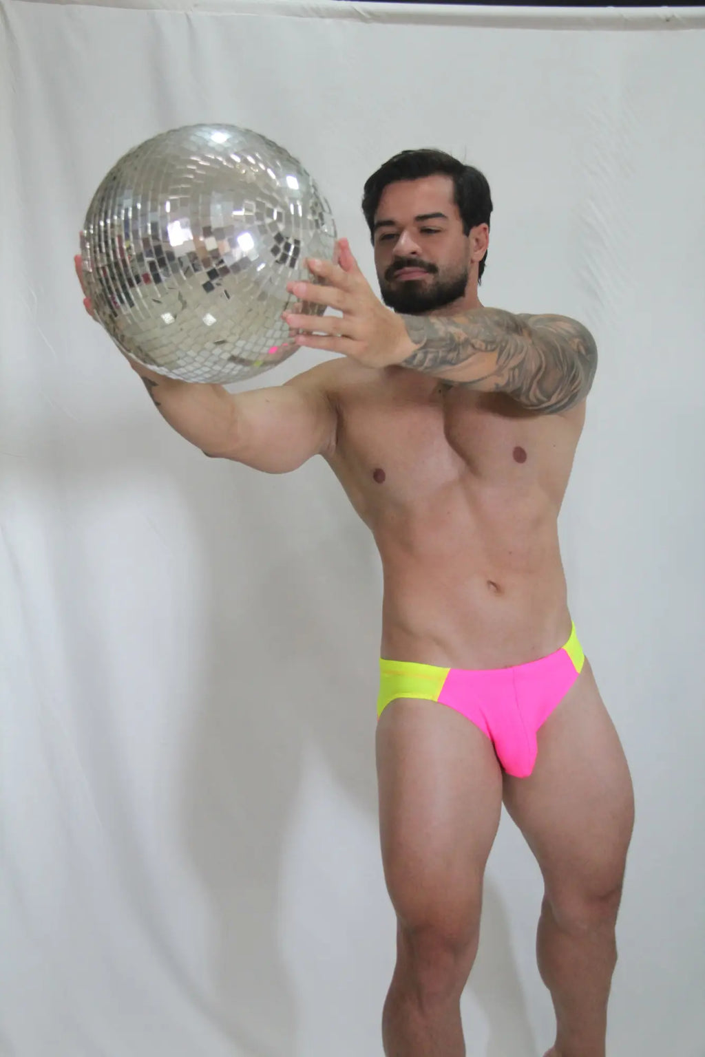 Neon curved swim brief with shiny silver disco ball mirrored facets reflecting light