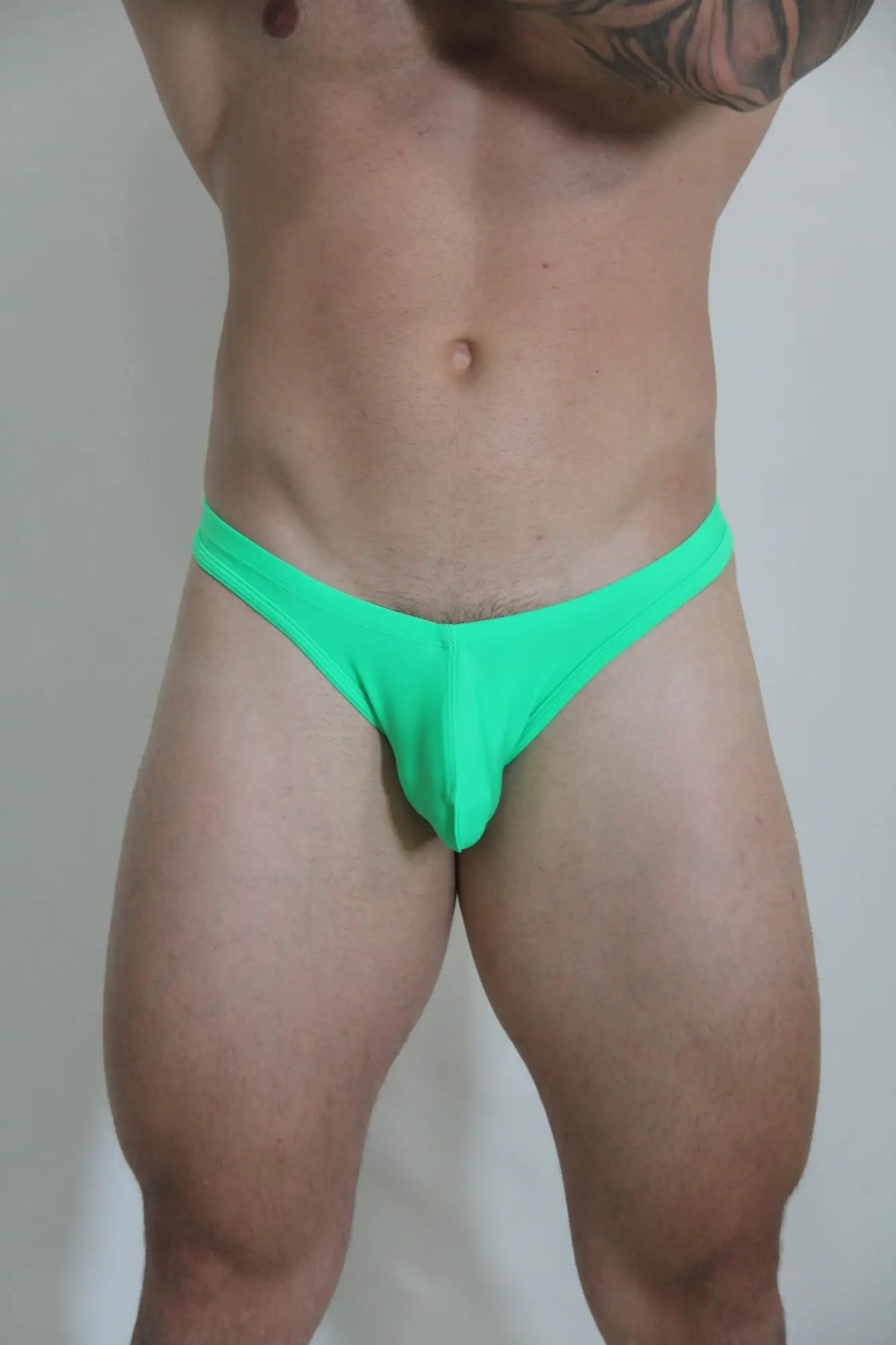 Bright green neon swim thong made of smooth fabric with form fitting design for stylish beachwear