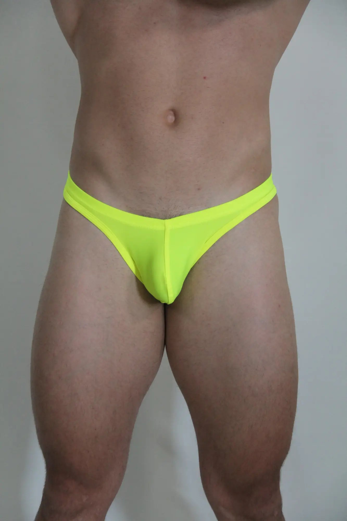 Neon yellow swim thong briefs in soft fabric shown from the front as part of 4 colors to choose collection