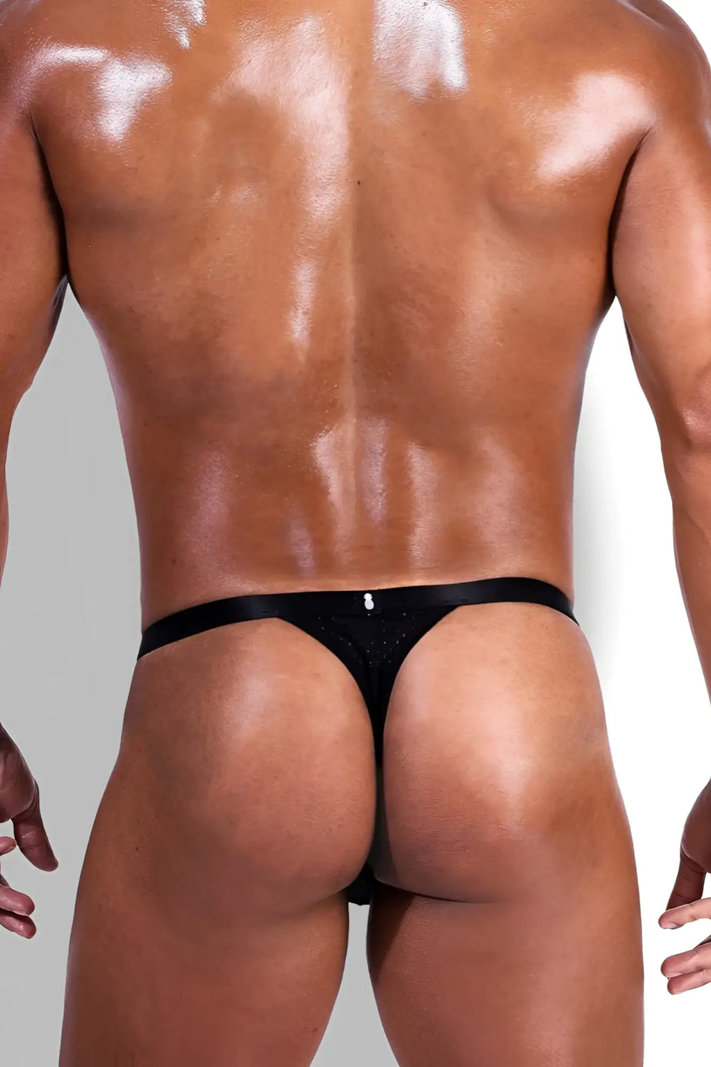 Back view of now-or-never mesh thong in black satin with subtle glittery texture and small silver logo