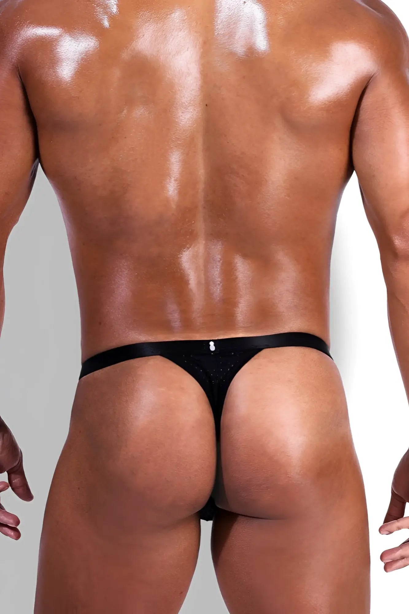 Back view of now-or-never mesh thong in black satin with subtle glittery texture and small silver logo