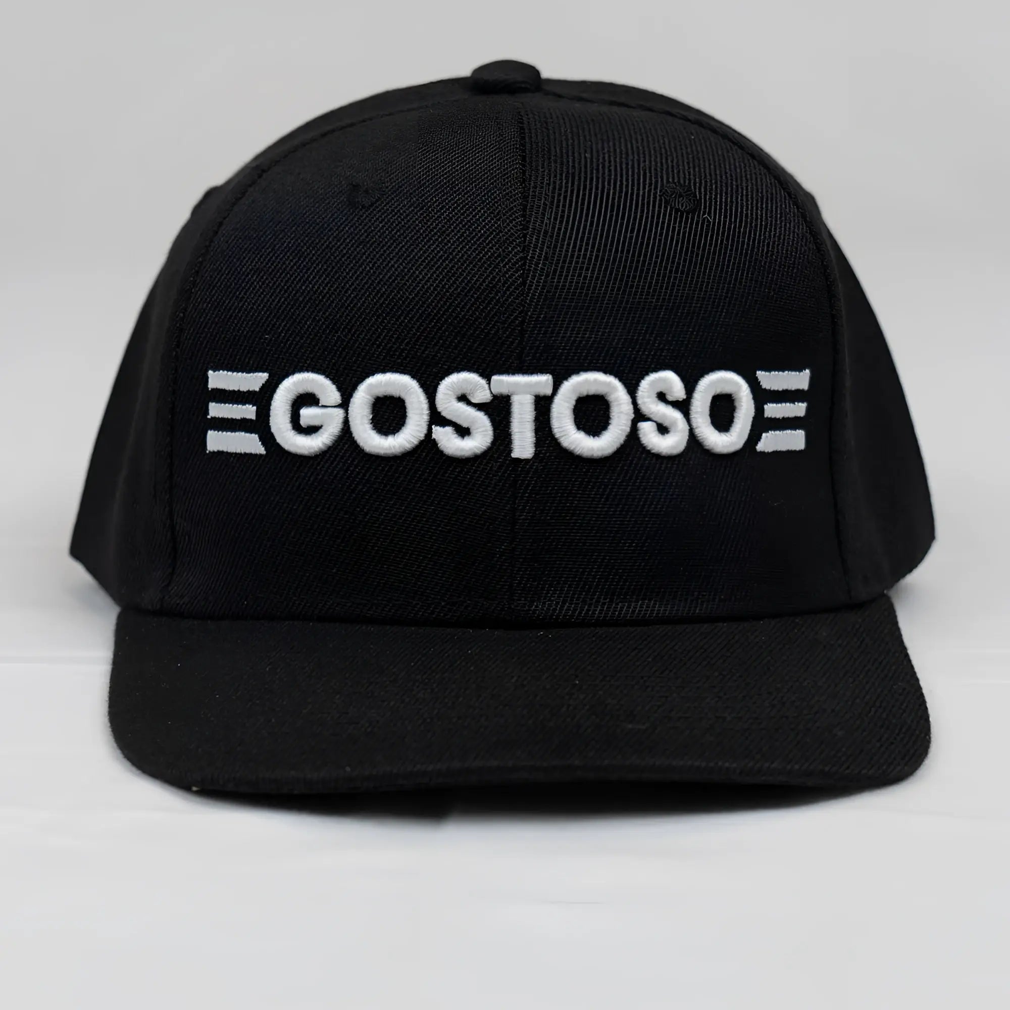 Black snapback cap with white embroidered 3D puff gostoso logo and triple horizontal stripes on each side