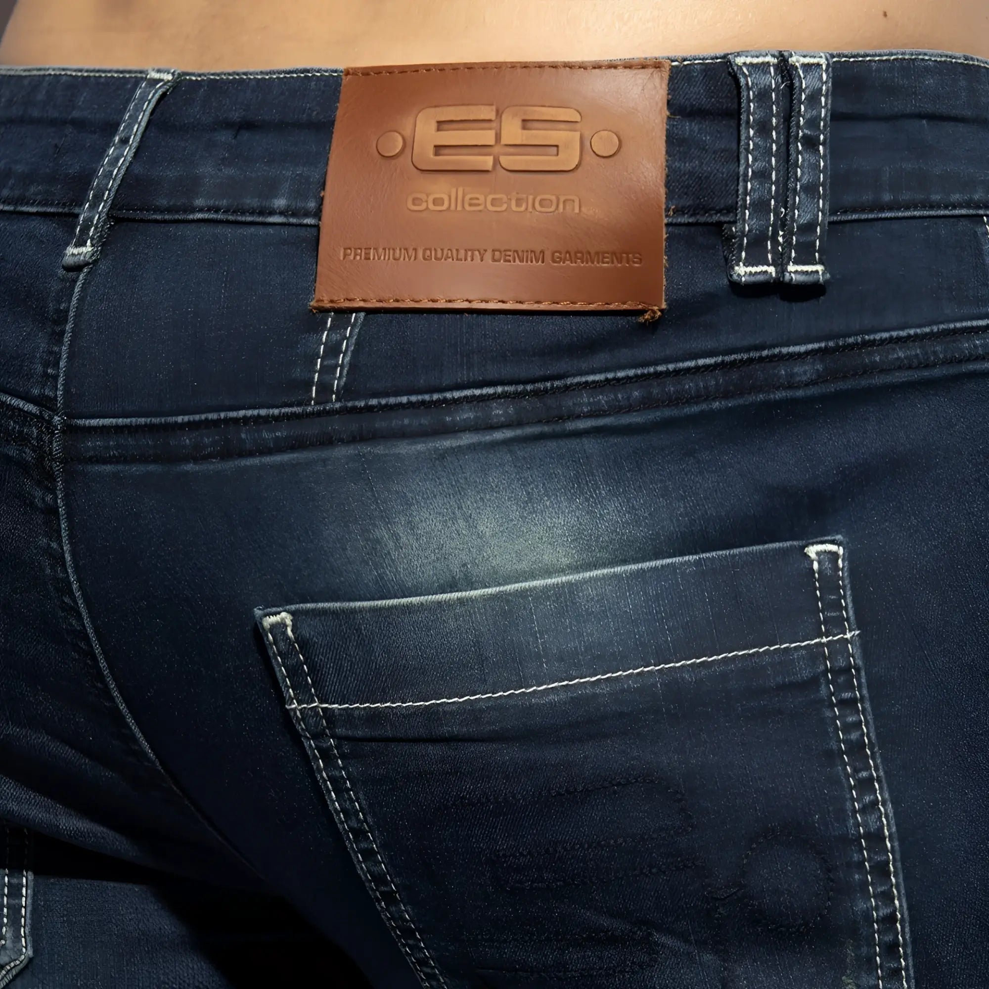 Dark blue denim bermuda jeans with a brown leather es collection patch on the back side