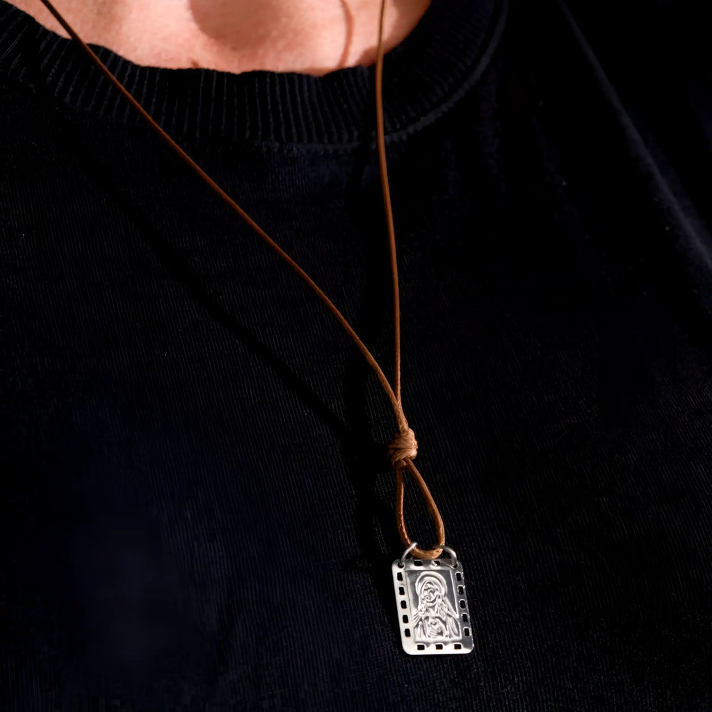 Silver rectangular pendant with filmstrip design and engraved nossa senhora do carmo on brown leather cord men’s necklace