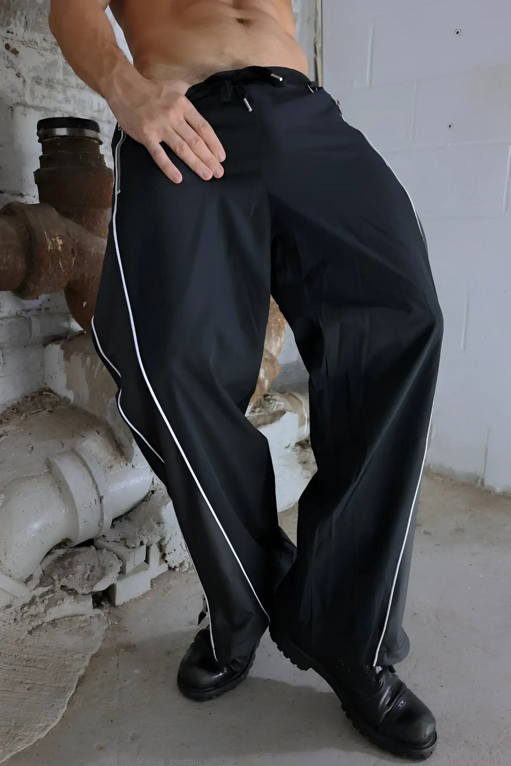 Black NSA track pants with white side stripes and a drawstring waistband made for athletic wear