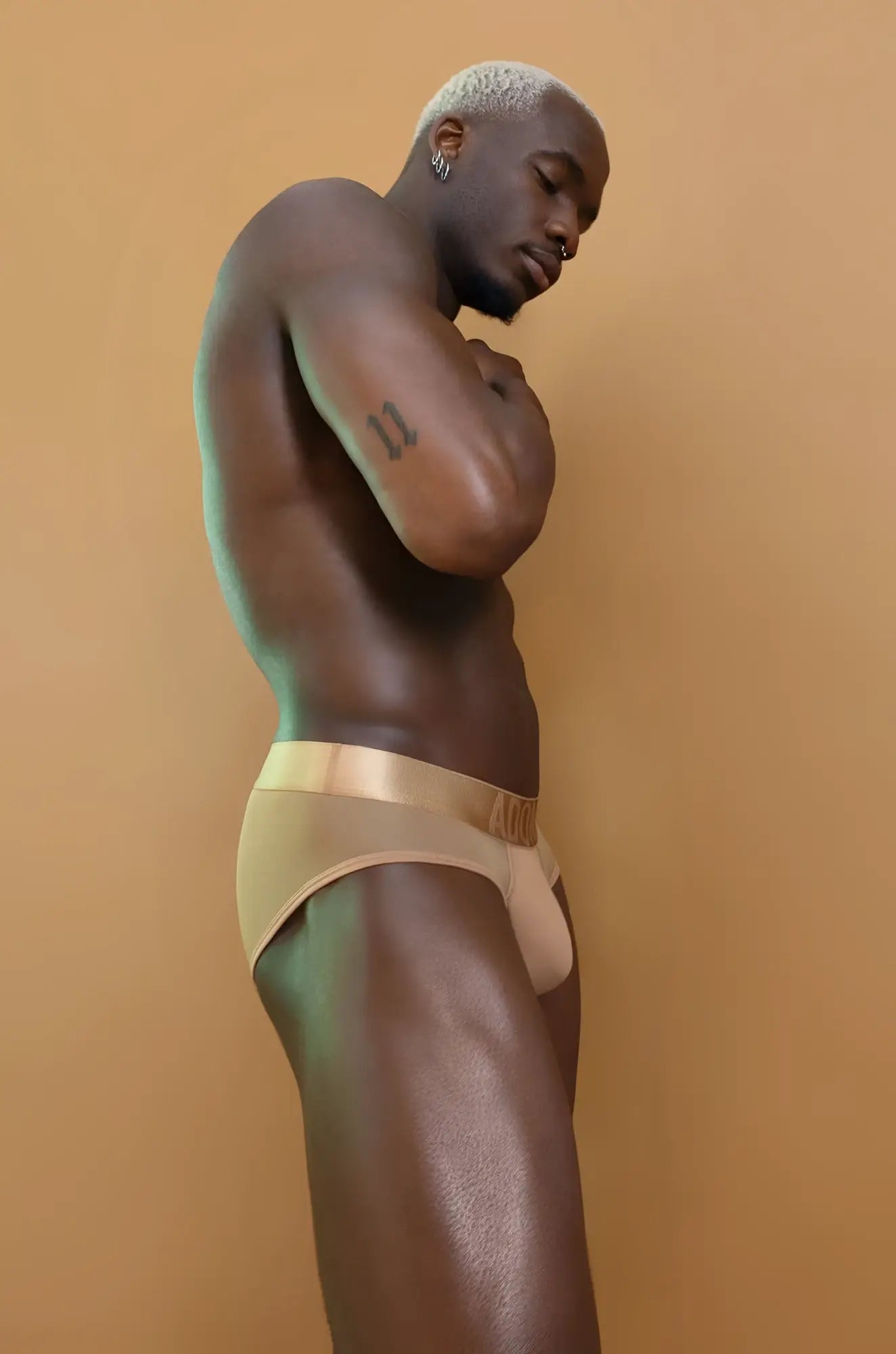Gold satin briefs with matching waistband featuring nude tan sheer cutout design in front view