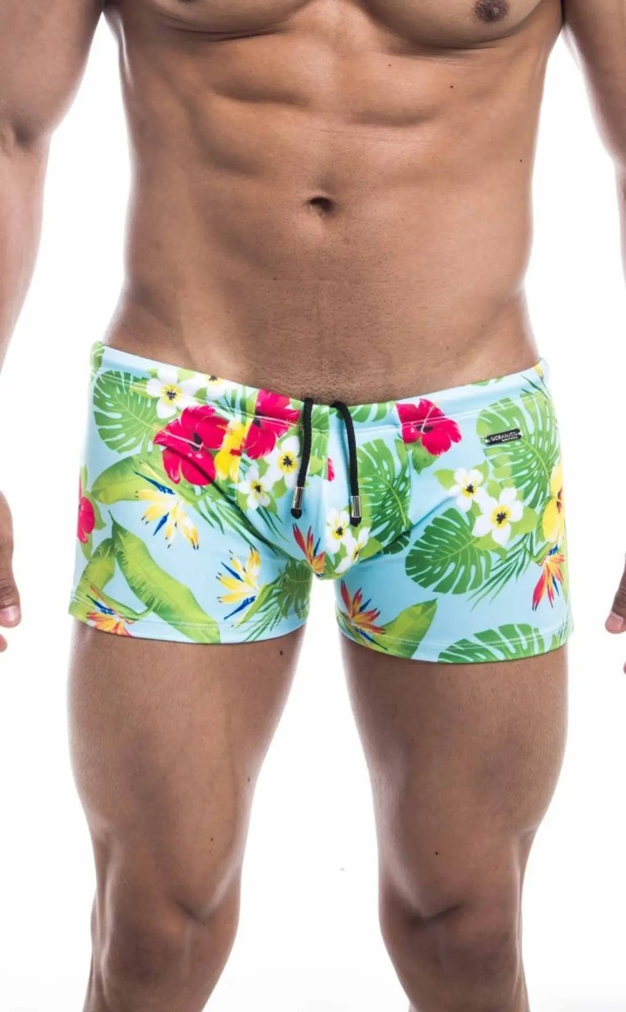 Oceanico square cut swim trunks in light blue with red hibiscus white flowers and green leaves tropical print