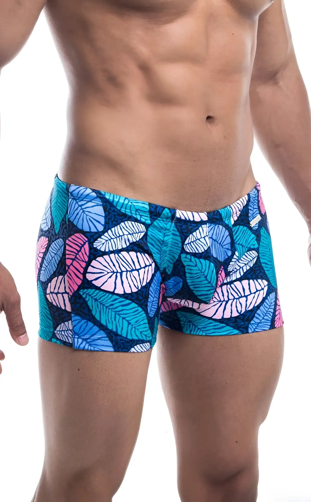 Oceanico Square Cut swim trunks featuring vibrant tropical leaf patterns in blue pink and teal on a navy base
