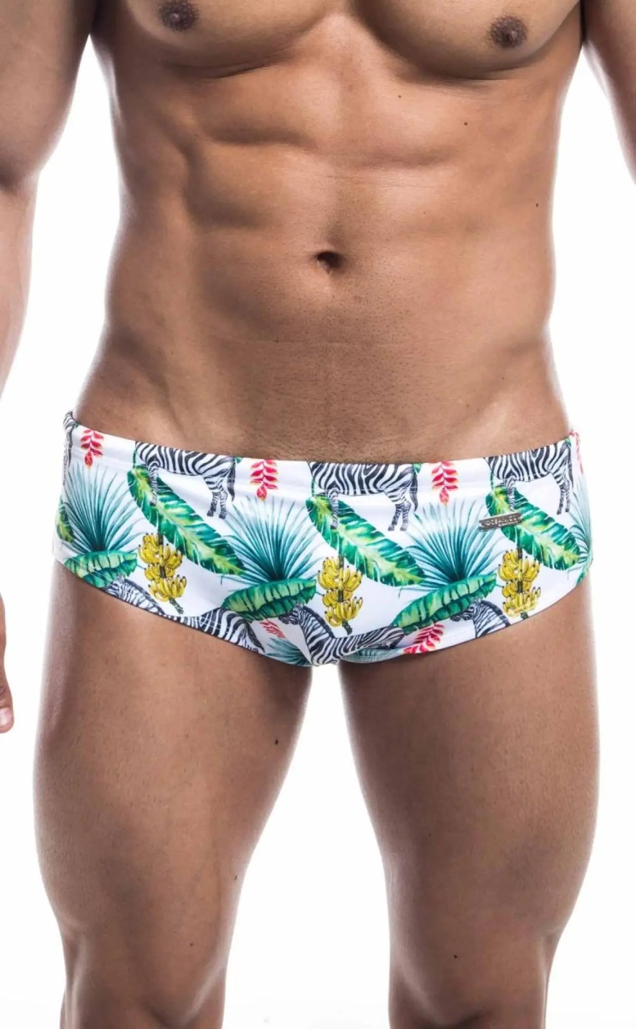 Oceanico swim brief white swim trunks with vibrant tropical pattern of green palm leaves yellow bananas pink flowers and zebras