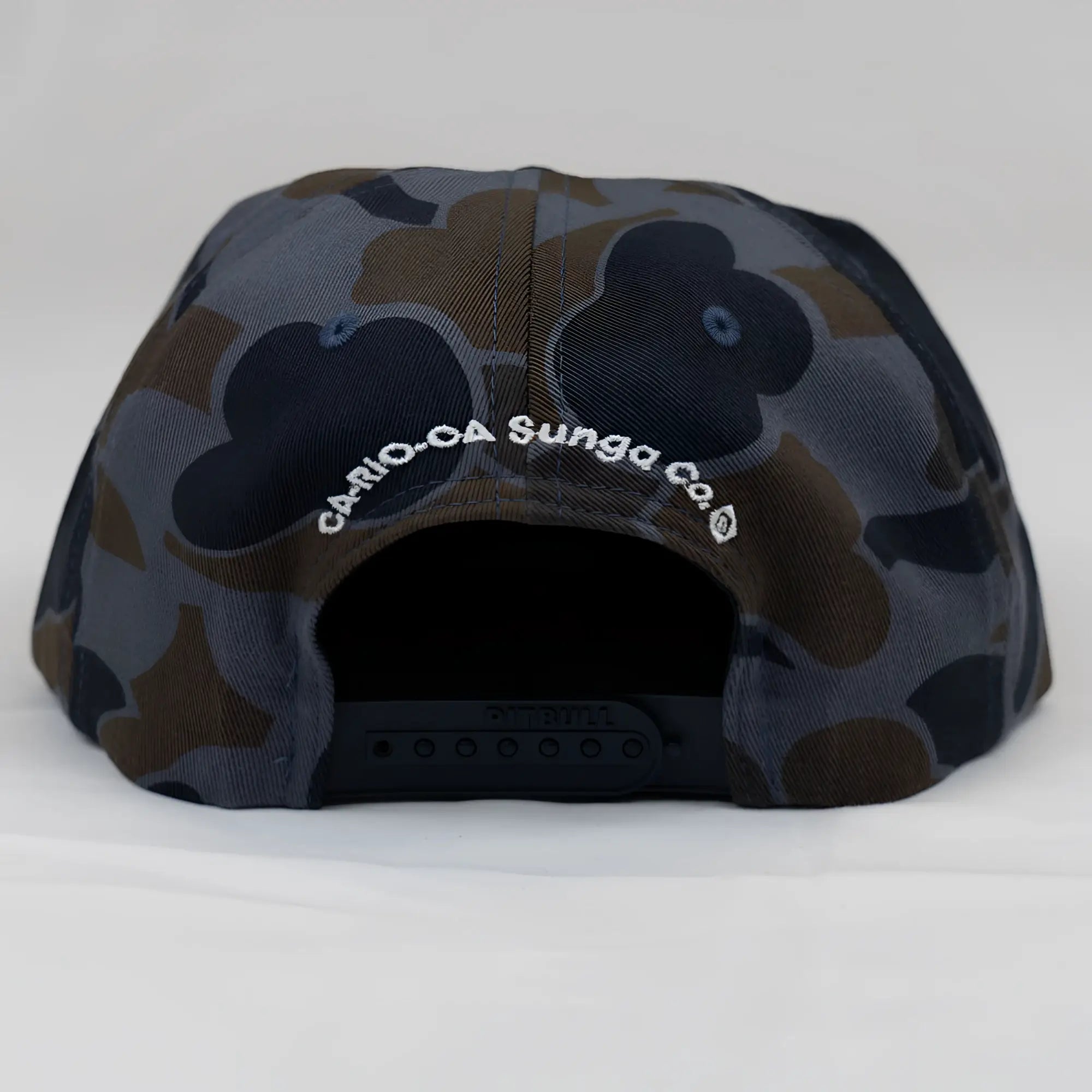 Back side of an old school camo unstructured rope hat in dark gray and brown camouflage with a white embroidered logo