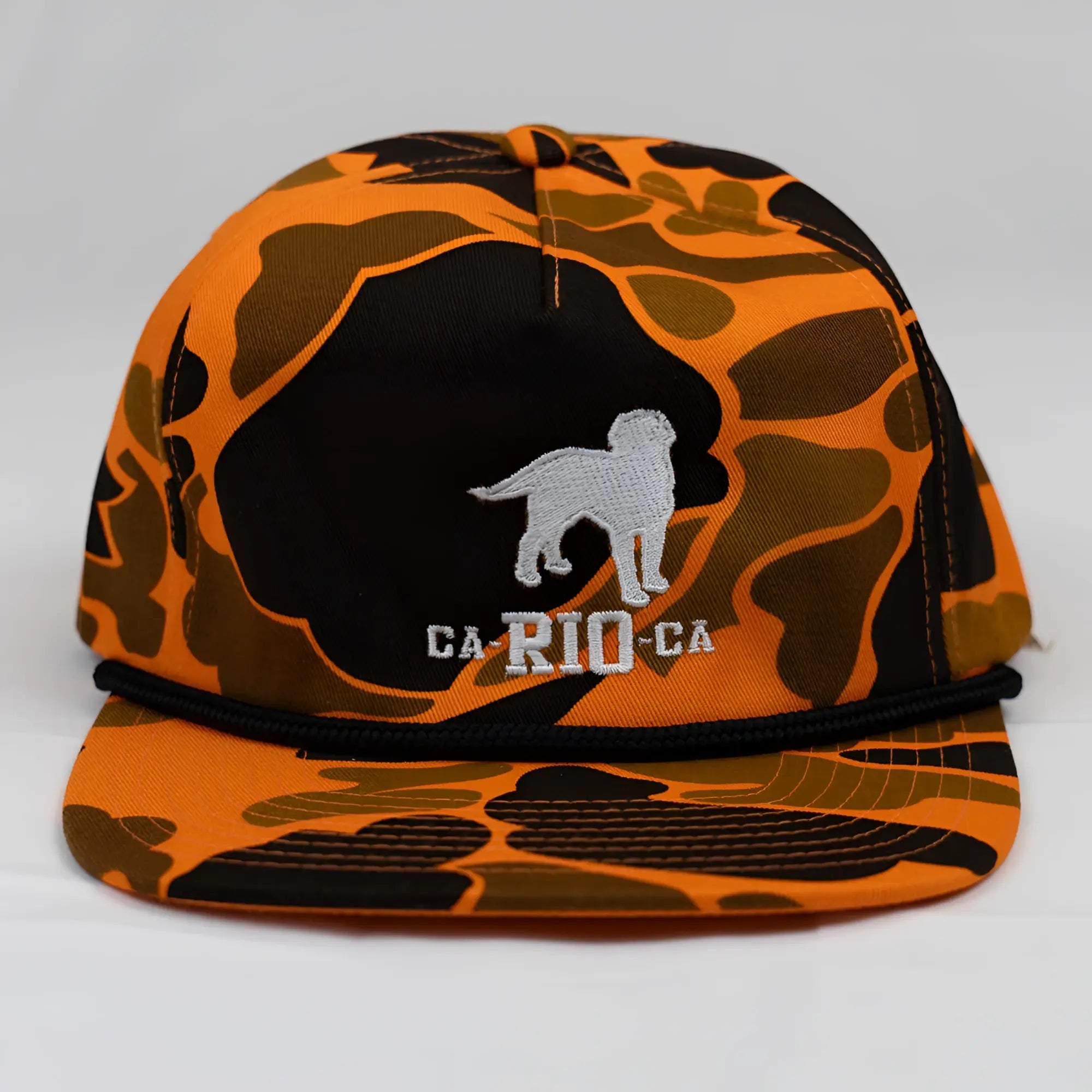 Orange and black camouflage unstructured snapback cap with silver embroidered dog silhouette and ca-rio-ca text