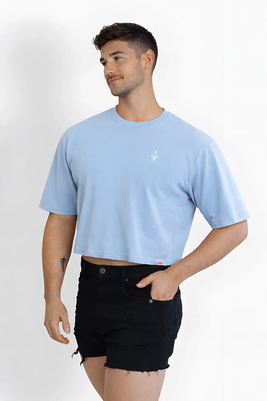 Light blue oversized relaxed crop top with small white embroidered logo on left chest in soft cotton fabric