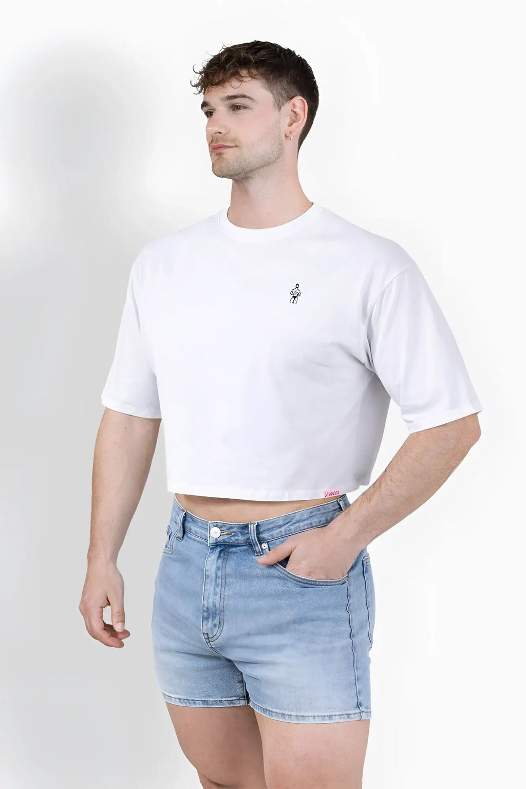 White oversized relaxed crop top in cotton with a small black embroidered graphic on the left chest