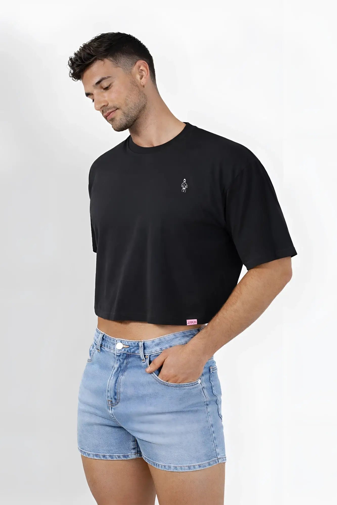 Black oversized relaxed crop top with small embroidered logo on left chest and pink brand tag at bottom hem